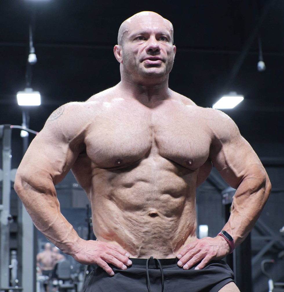 bodybuilder standing confidently in a gym.