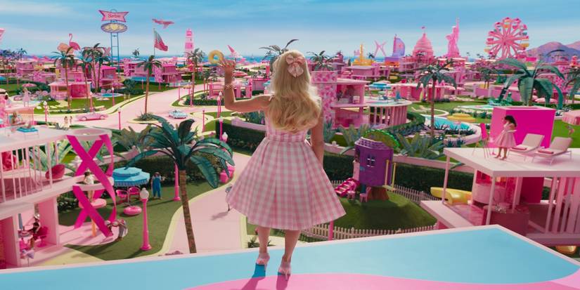 Margot Robbie as Barbie, standing on the Dream House and waving down at Barbieland in Barbie