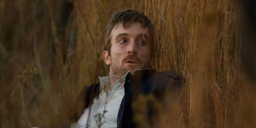 Wikus (Sharlto Copley) hiding in the tall grass in District 9