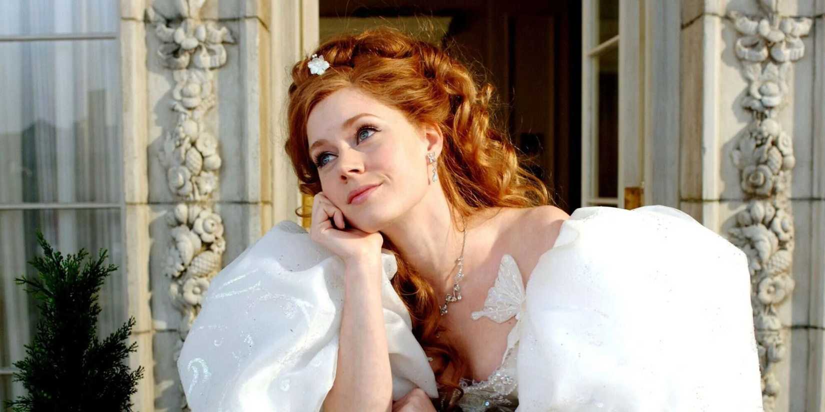 Amy Adams as Giselle on a balcony in a large wedding dress with a dreamy expression on her face in Enchanted.