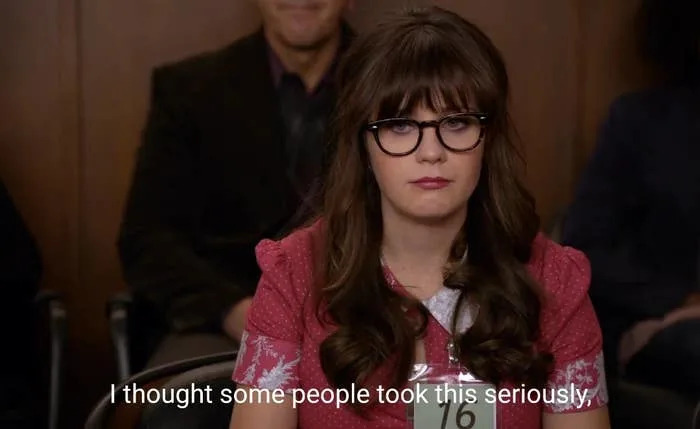 Person wearing glasses sits in an audience looking serious. Caption reads, 