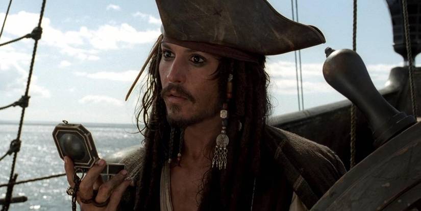 Captain Jack Sparrow stands at the helm of the Black Pearl, gazing out as he holds his compass