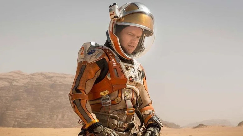 Mark Watney wearing a space suit and looking down in The Martian
